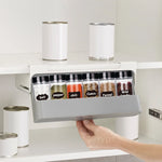 Wall-mounted under-shelf spice rack with pull-out compartment for organizing up to seven spice jars, featuring durable food-grade materials and drill-free 3M adhesive installation for modern kitchens.